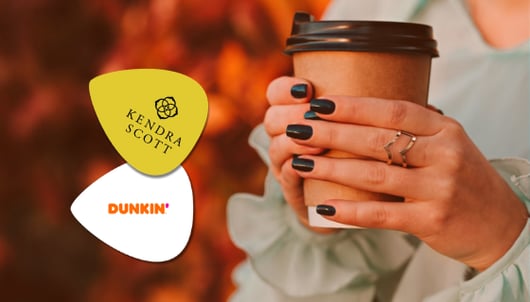 Kendra Scott and Dunkin’ gift cards beside a hand holding a coffee cup.